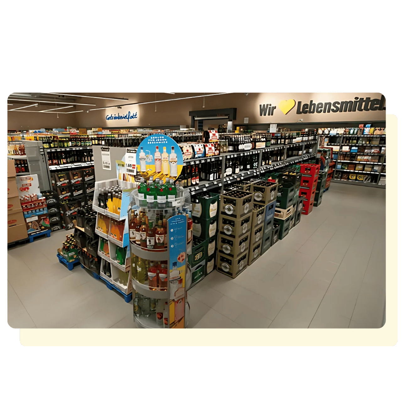 Gang in einem Supermarkt mit Regalen voller Getränkeflaschen, Weinflaschen und Bierkästen.